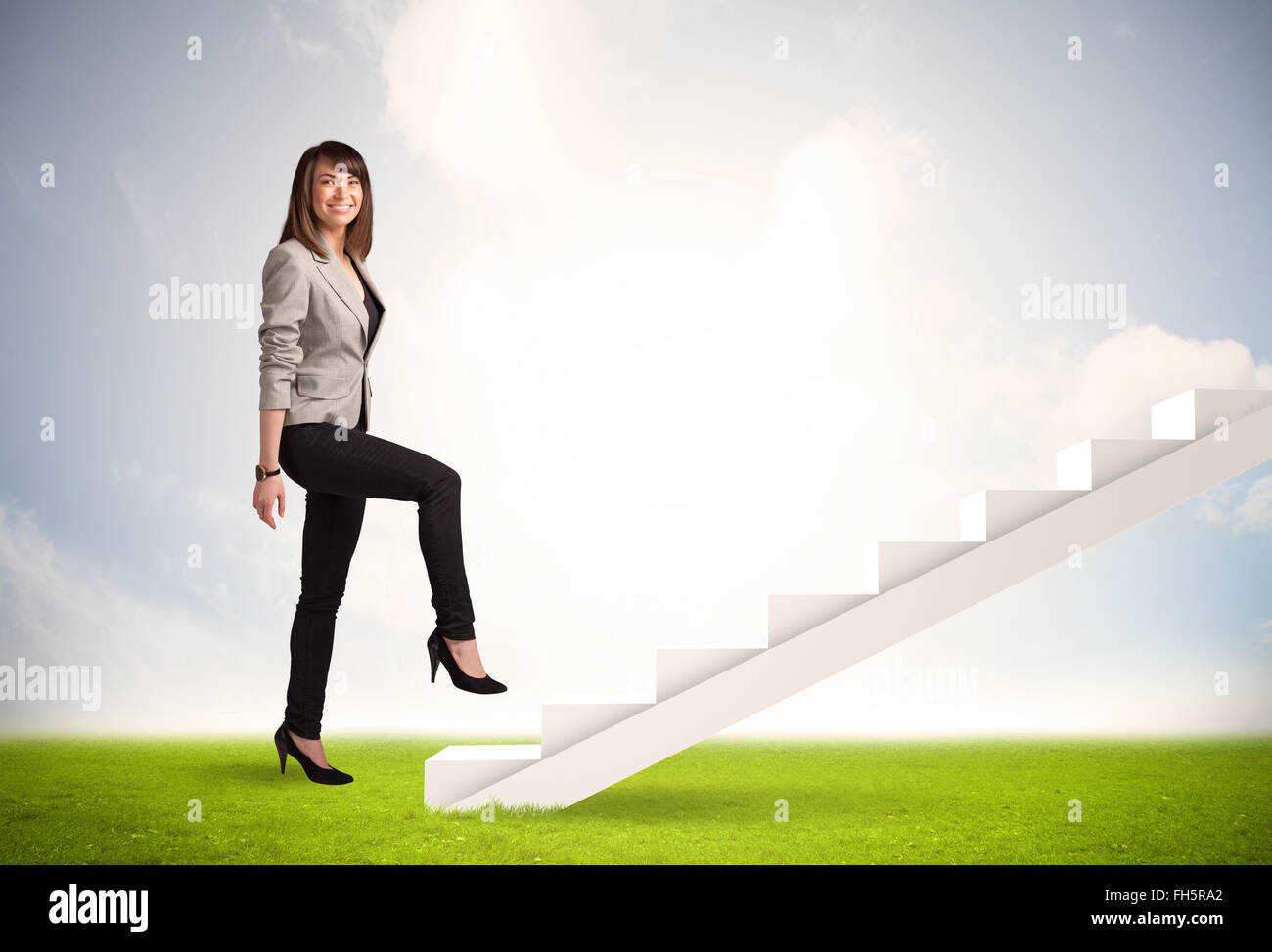 Business person climbing up on white staircase in nature Stock Photo