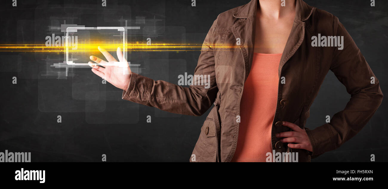 Young tech lady touching button with orange light beams concept Stock ...