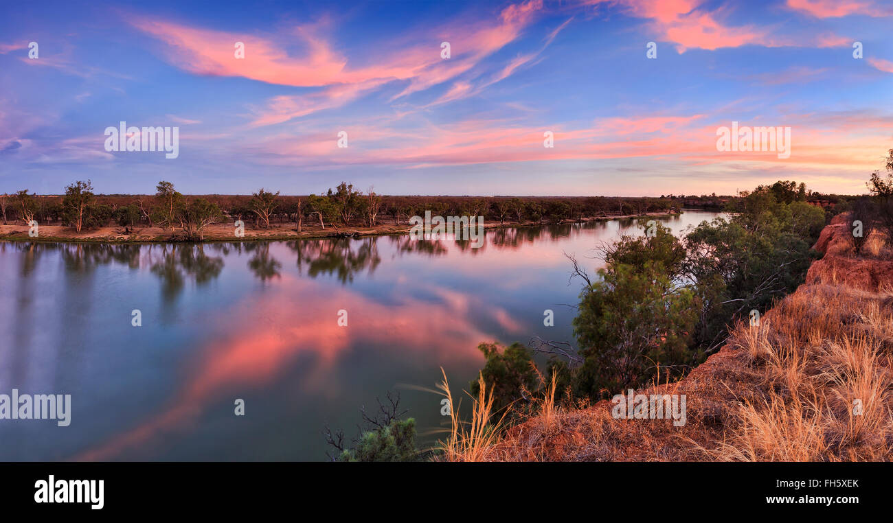 at the edge of shart red cliffs in Victoria on Murray river at sunset. Bending river flows in agricultural region of Australia Stock Photo