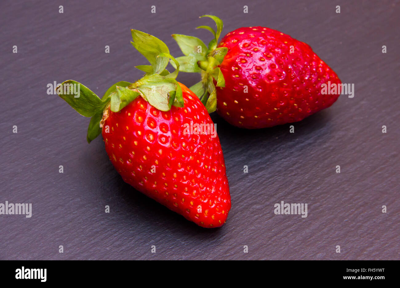 Strawberries on top in slate seen up close Stock Photo - Alamy
