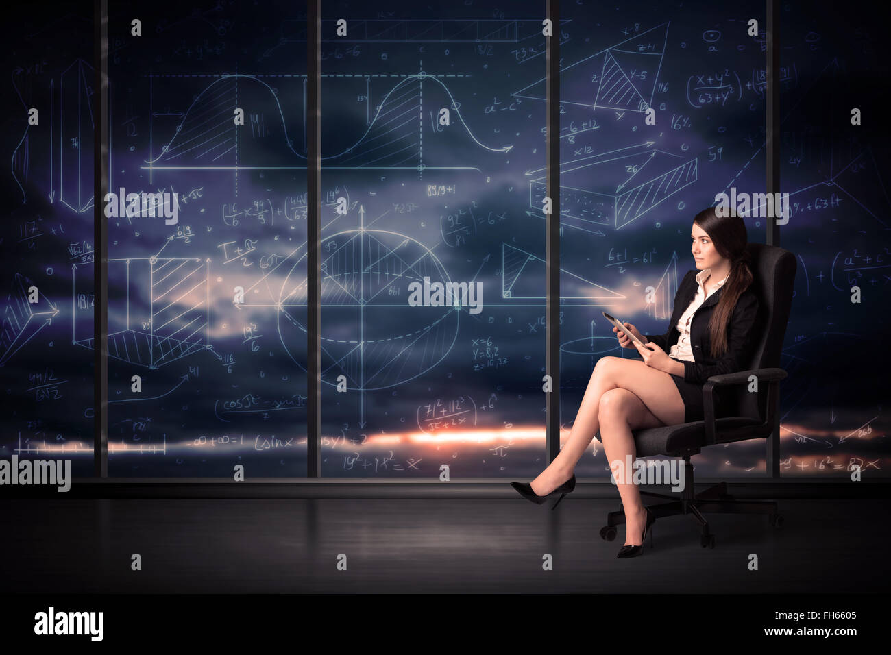 Businesswoman holding tablet in office room with graph charts on window ...