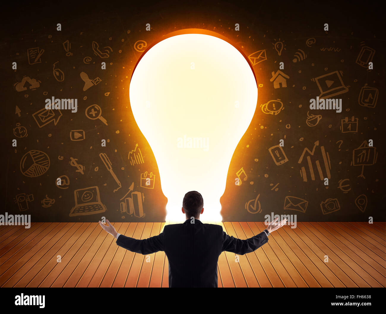 Business man looking at bright light bulb in the wall Stock Photo