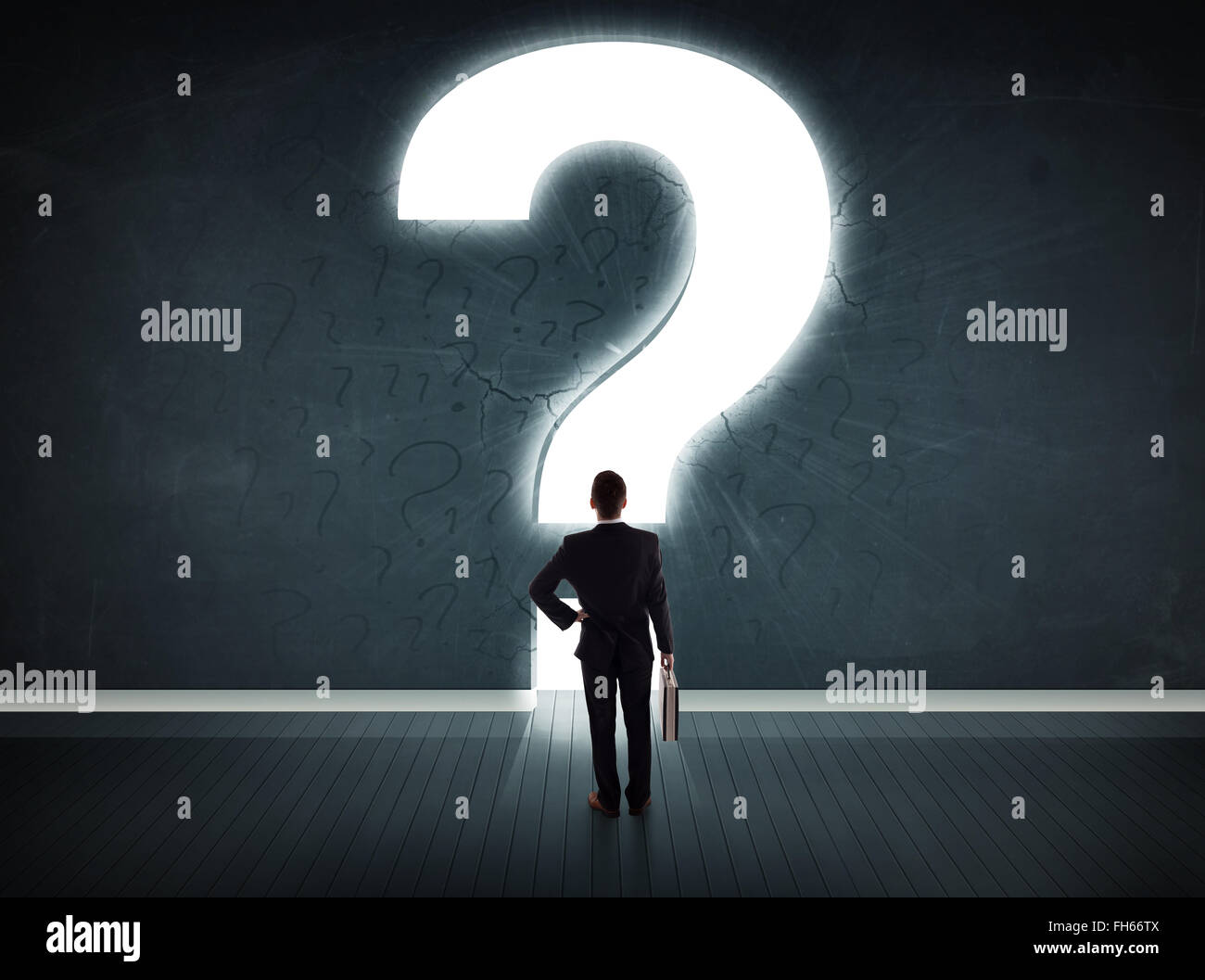 Business man looking at wall with a bright question mark Stock Photo ...