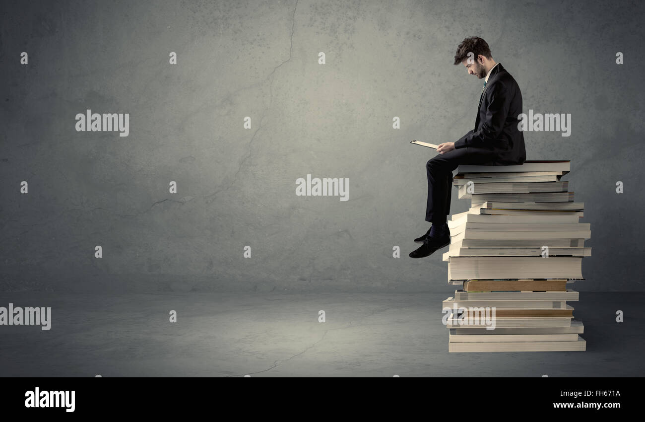 Student sitting on pile of books Stock Photo - Alamy