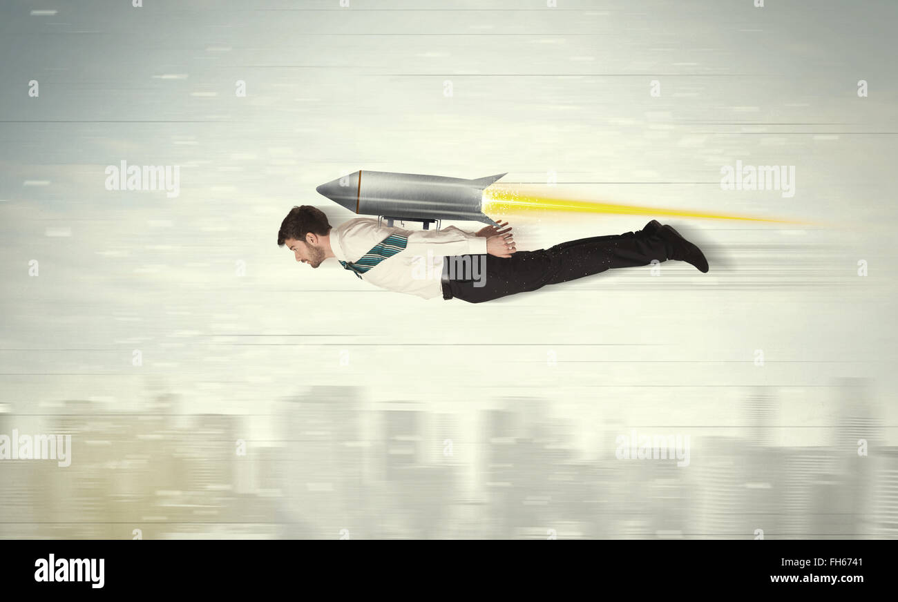 Superhero business man flying with jet pack rocket above the city Stock Photo