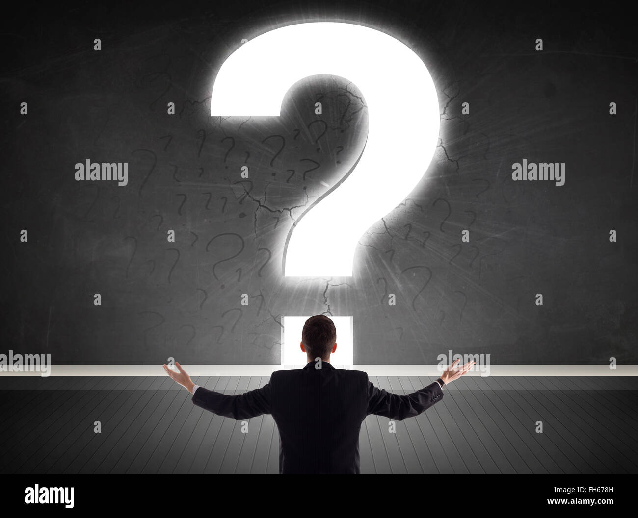 Business man looking at wall with a bright question mark Stock Photo ...