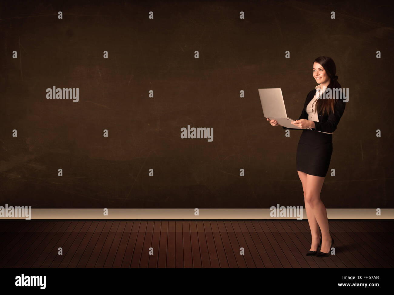 Businesswoman holding high tech laptop on background with copyspace Stock Photo