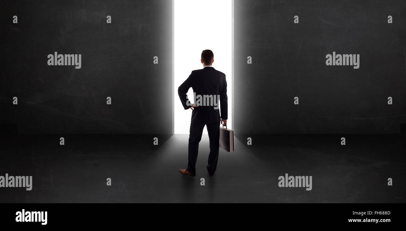 Business person looking at wall with light tunnel opening Stock Photo