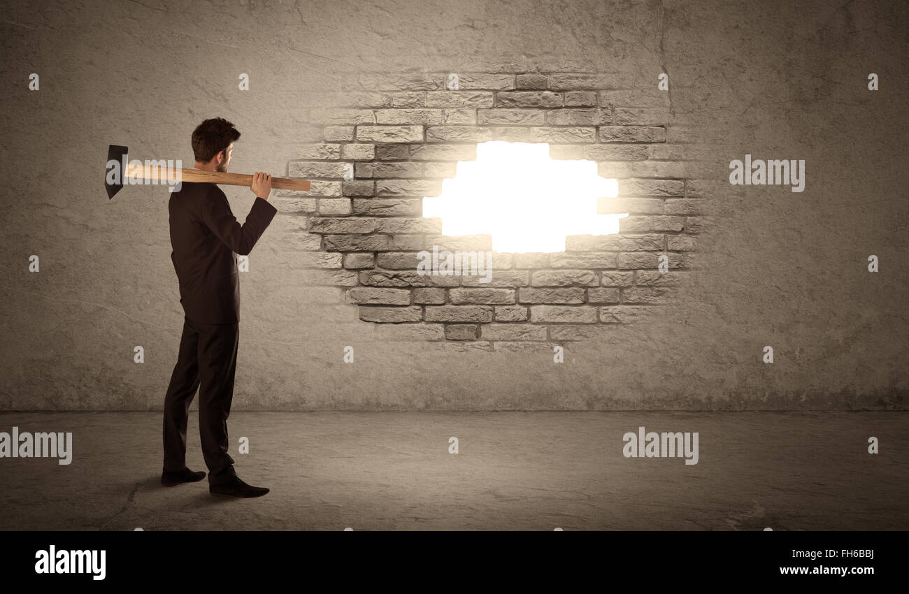 Business man hitting brick wall with hammer and opening a hole Stock Photo Alamy