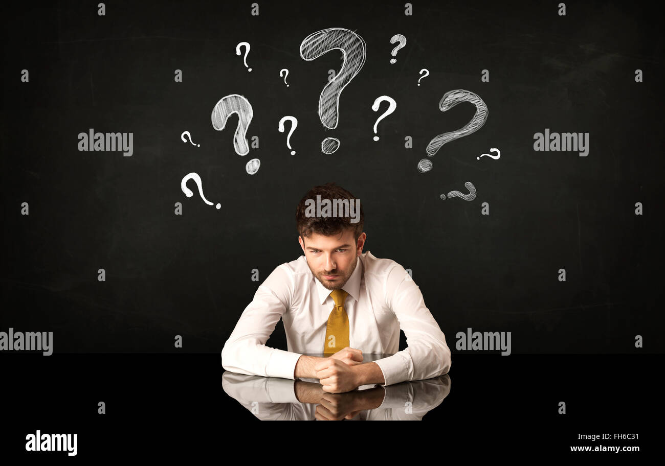 Sitting businessman under question marks Stock Photo - Alamy