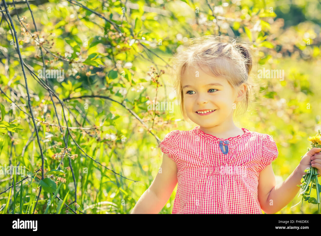 Happy little girl in spring sunny park Stock Photo - Alamy