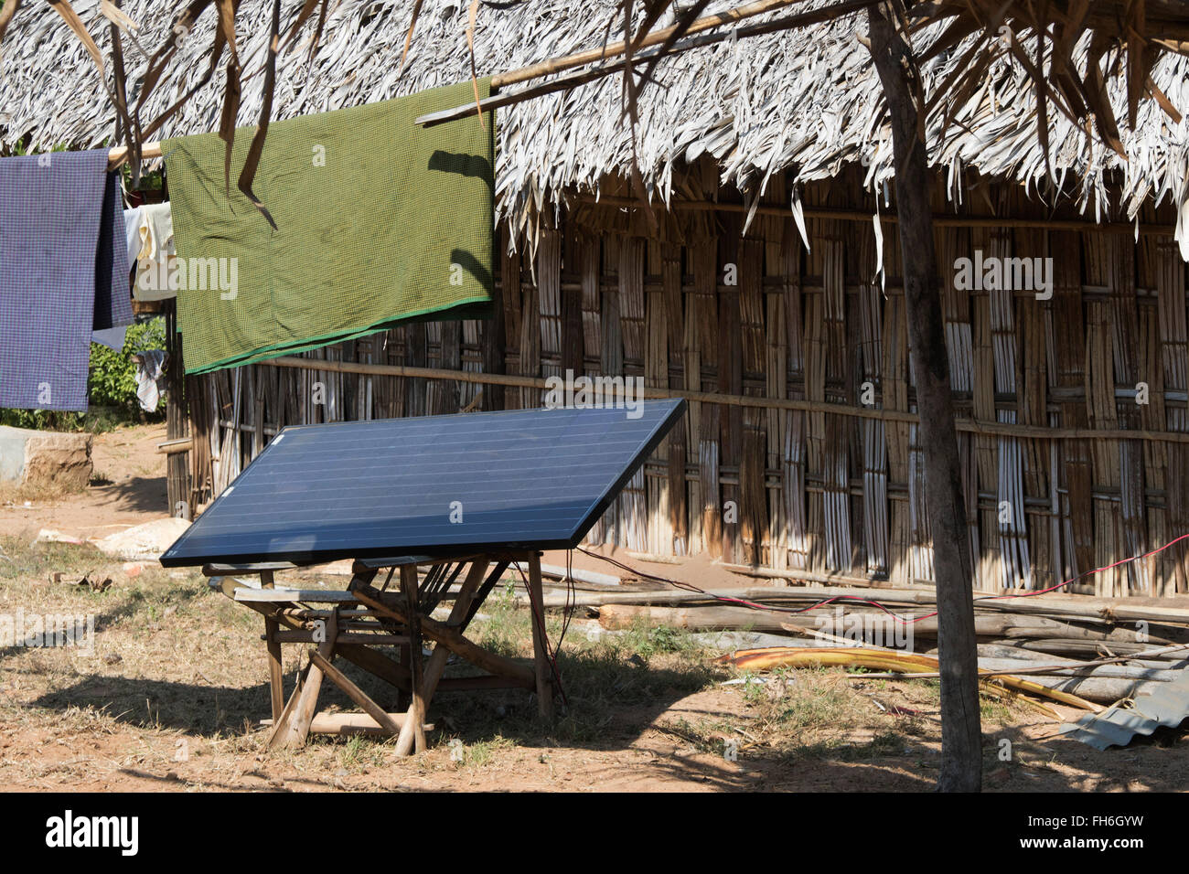 Solar panel provides electricity to rual huts off the power grid rural Myanmar Stock Photo