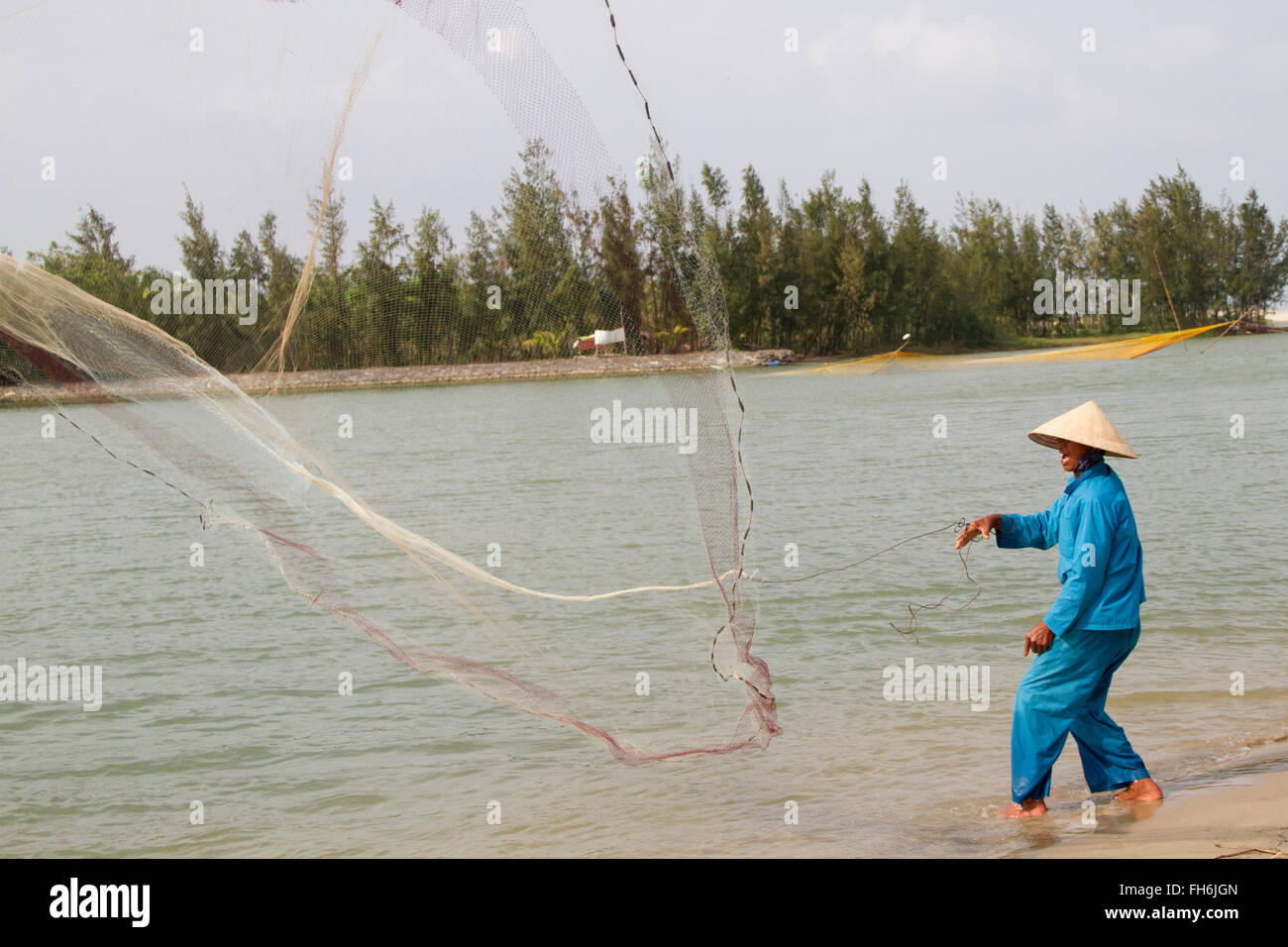 Fisherman uses a throw net to fish Hoi An, Vietnam Stock Photo - Alamy