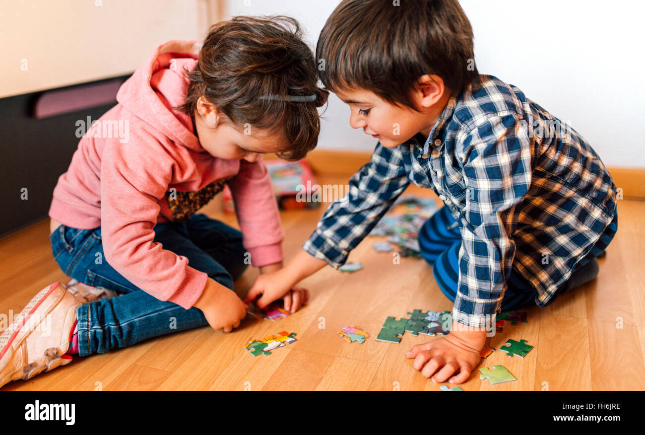Boy and girl doing a jigsaw on the floor together Stock Photo - Alamy