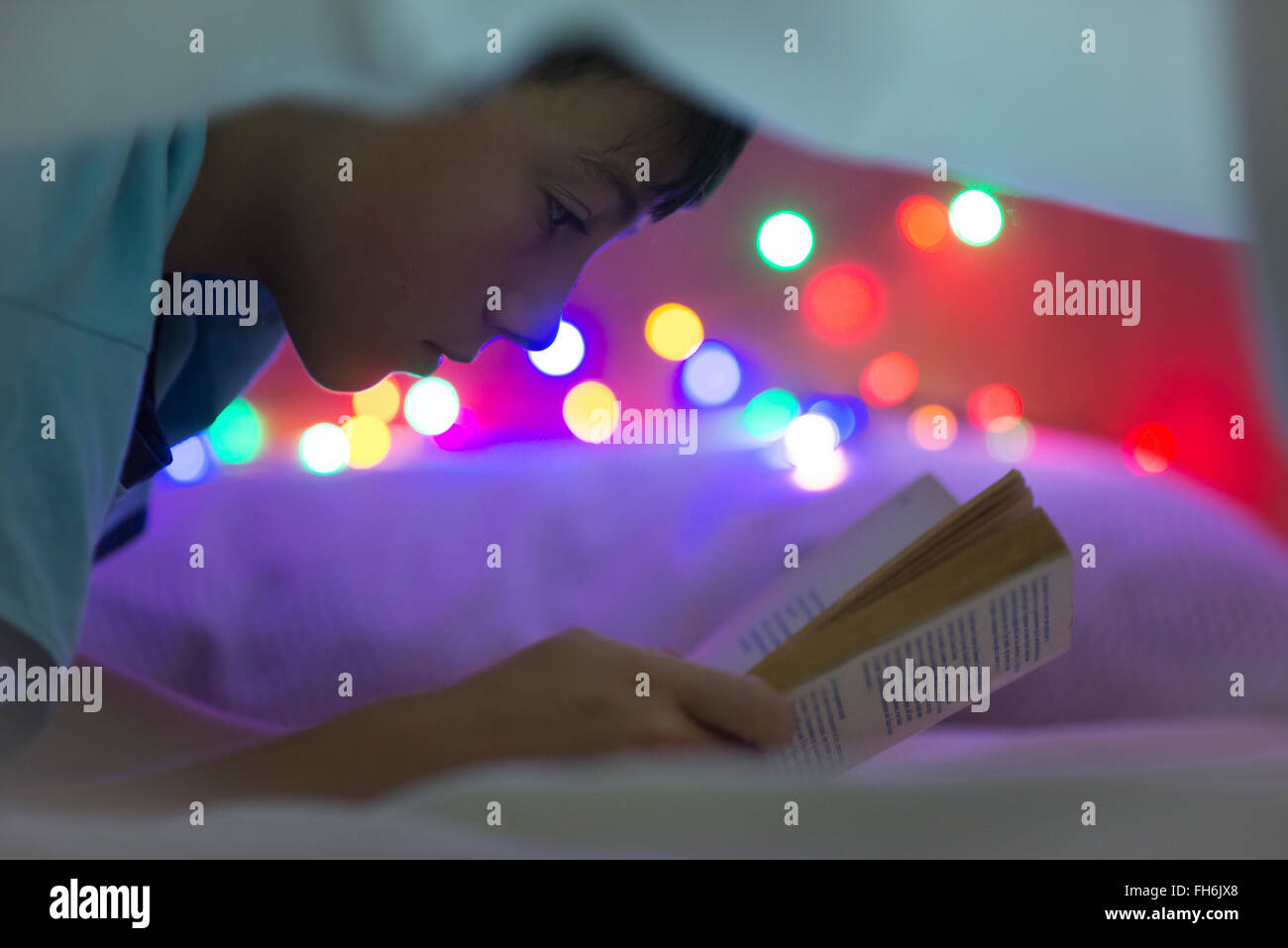 Boy reading book under a blanket Stock Photo Alamy