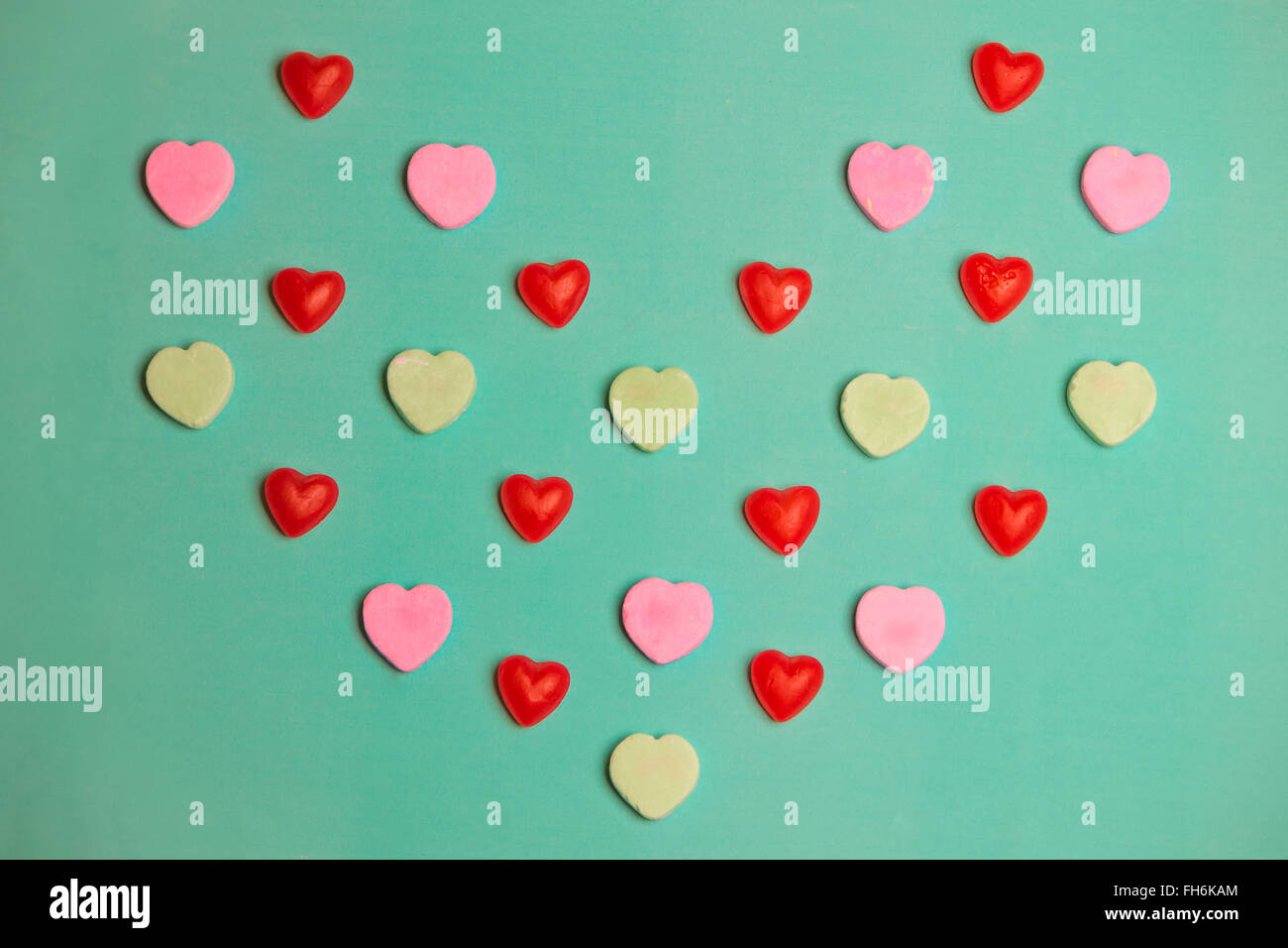 Valentine's Day Red Gummy and Conversation Hearts on Green Background