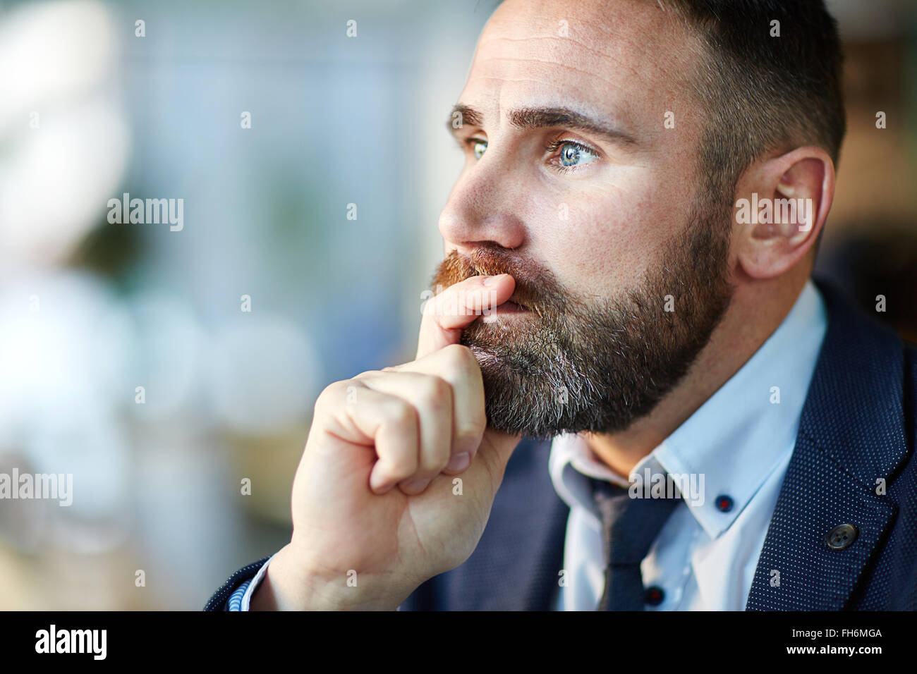 Pensive man touching his chin Stock Photo - Alamy