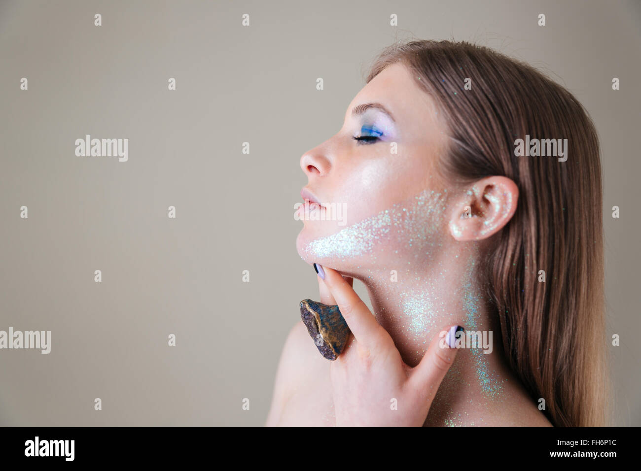 Beauty portrait of a lovely woman with closed eyes posing over gray ...