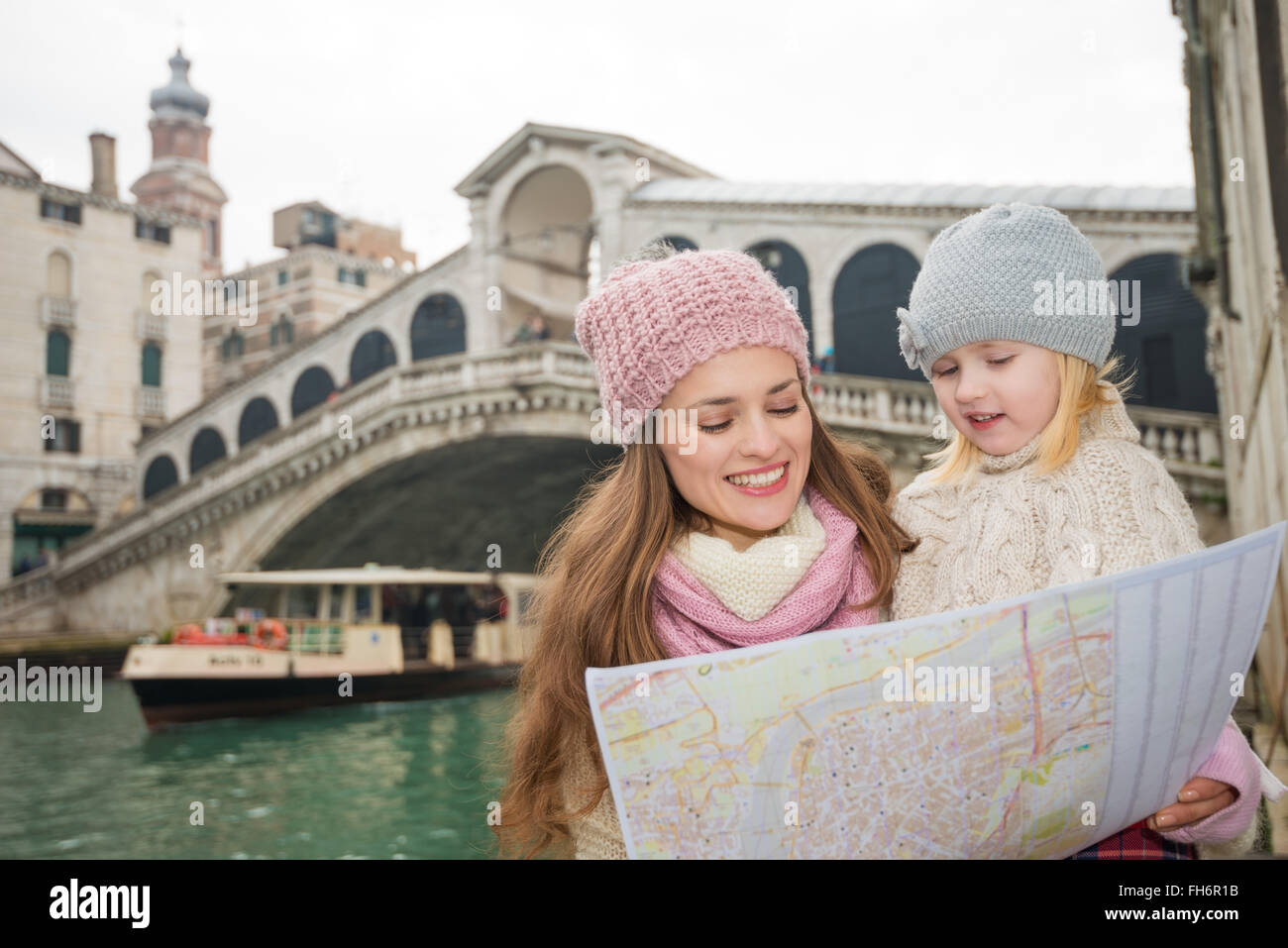 Modern family taking a winter break to enjoy inspirational adventure in Venice, Italy. Mother and daughter looking in map while Stock Photo