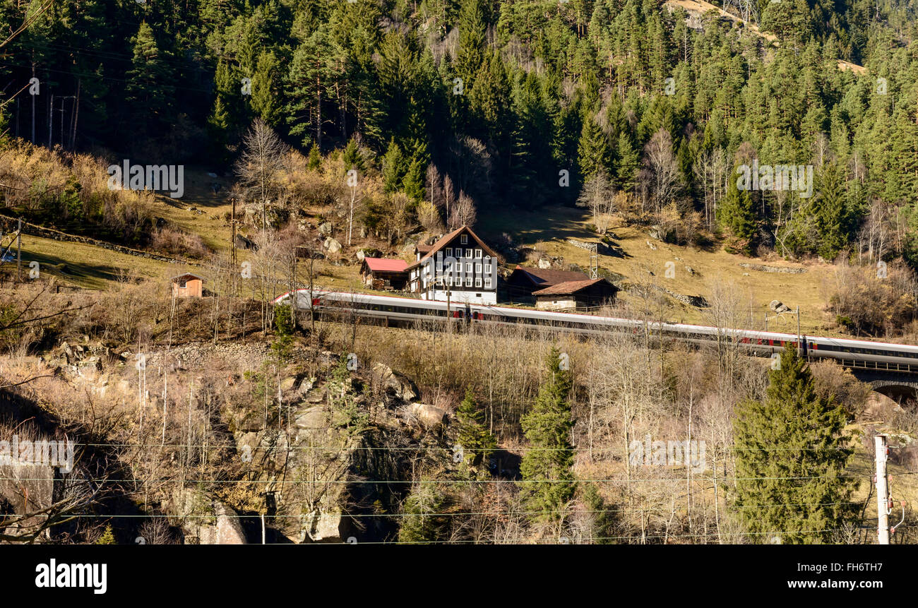 fast train and old chalet on a sunny slope near Wassen , Switzerland Stock Photo