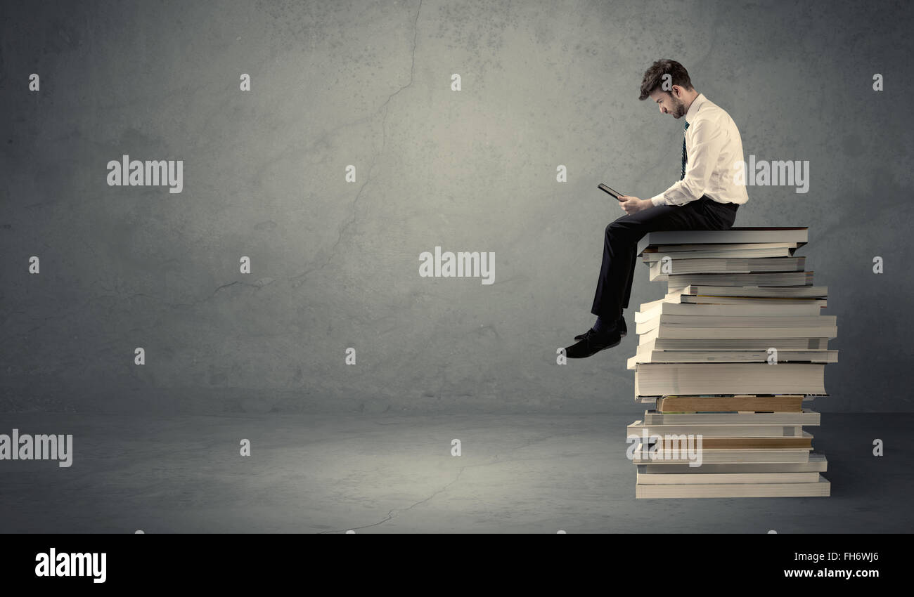 Student sitting on pile of books Stock Photo - Alamy