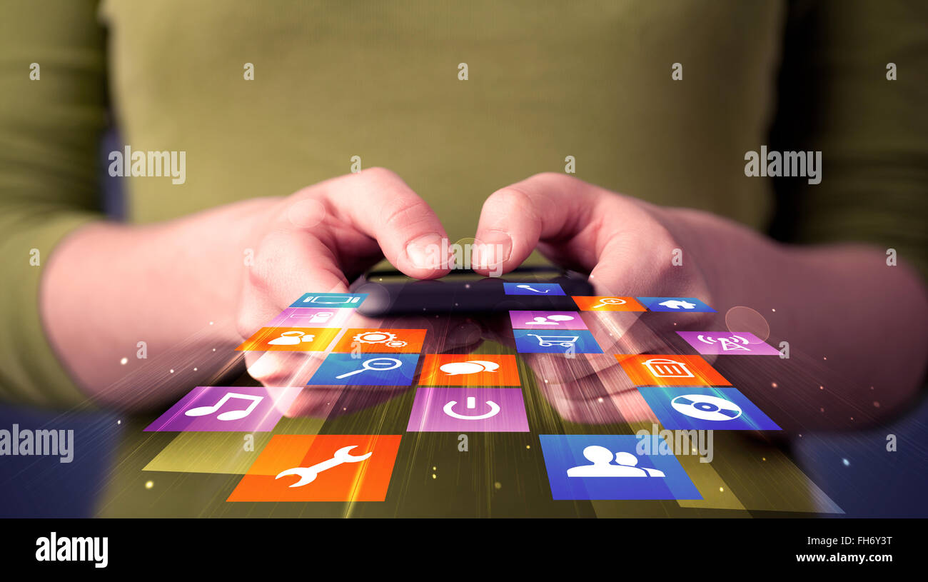 Woman holding smart phone with colorful application icons Stock Photo ...