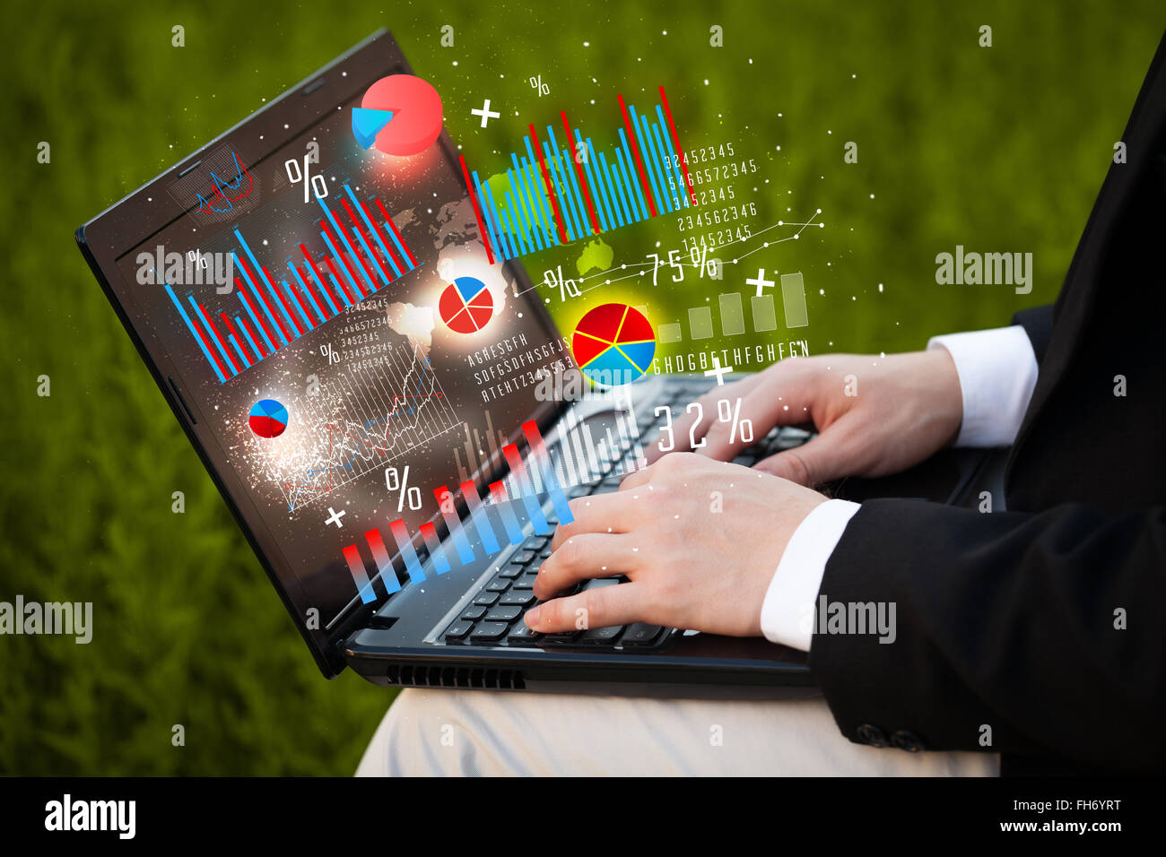 Hand typing on modern laptop notebook computer with graph icons and ...