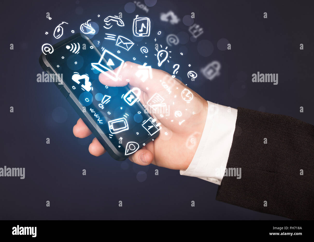 Hand holding smartphone with media icons and symbol Stock Photo