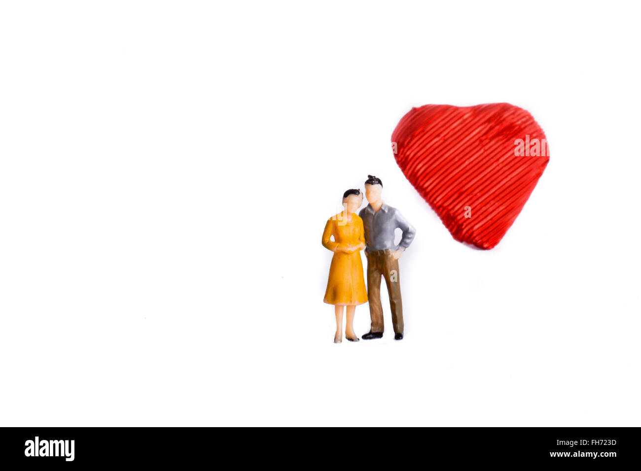 Couple standing in front of a heart shape on a white background Stock ...