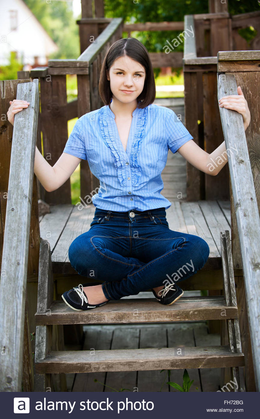 Young Woman Sits On Wooden Ladder Young Woman Sits On Wooden Ladder