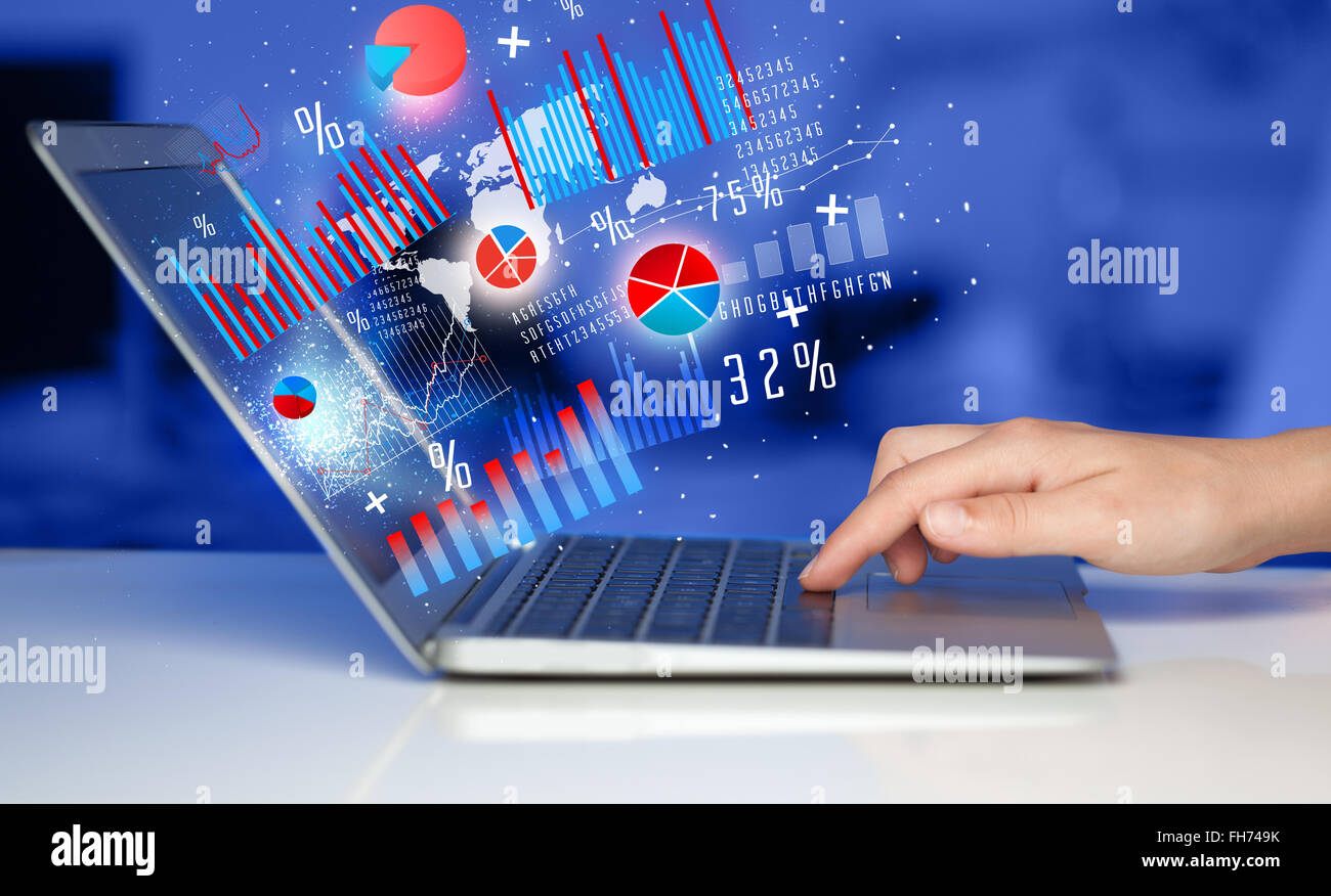 Hand typing on modern laptop notebook computer with graph icons and ...