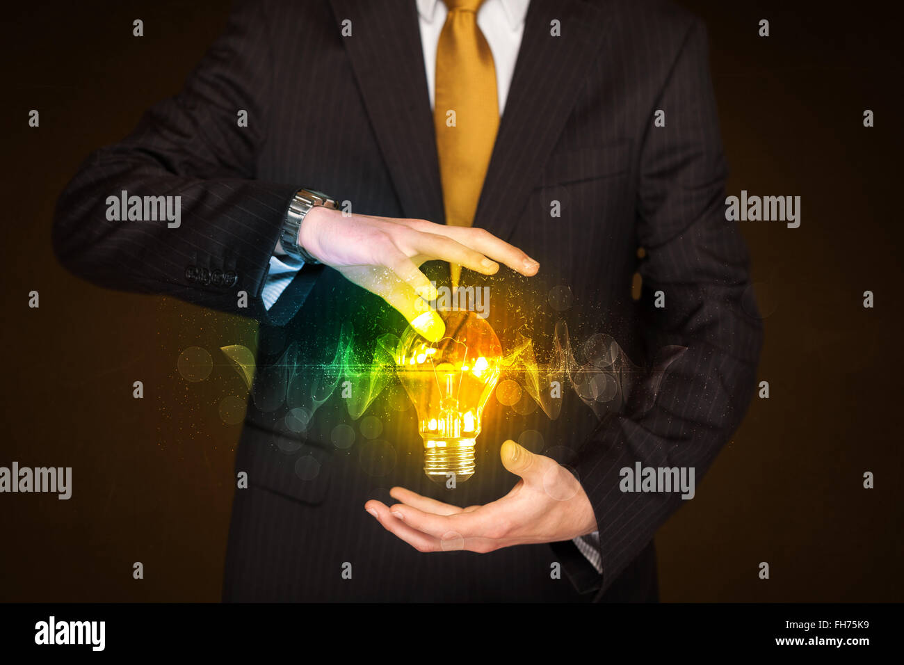 Businessman holding light bulb Stock Photo - Alamy