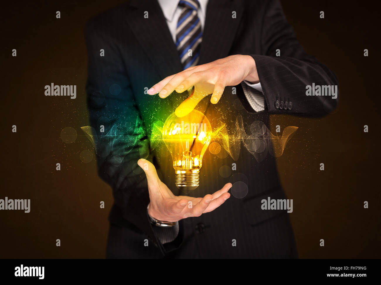 Businessman holding light bulb Stock Photo - Alamy