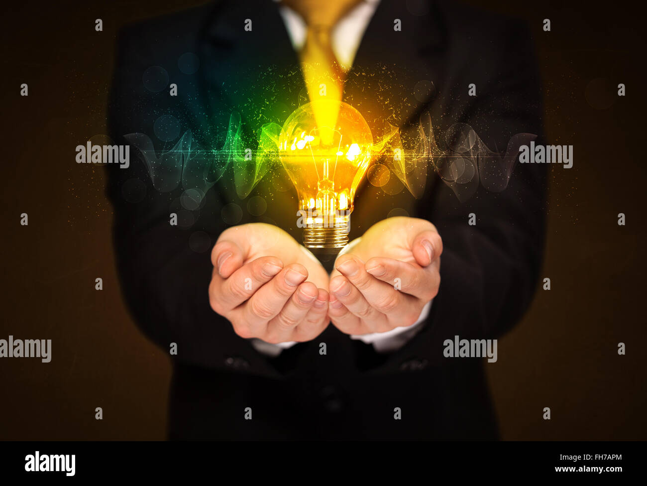 Businessman holding light bulb Stock Photo - Alamy
