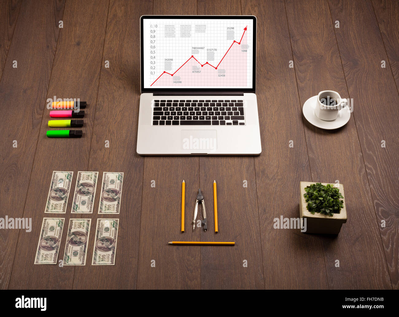 Computer desk with laptop and red arrow chart in screen Stock Photo - Alamy