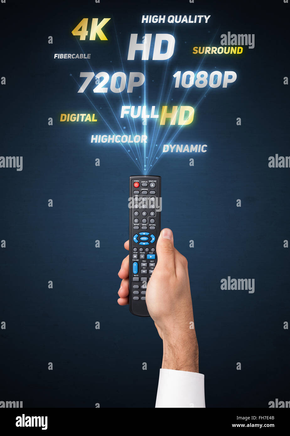 Hand with remote control and multimedia properties Stock Photo