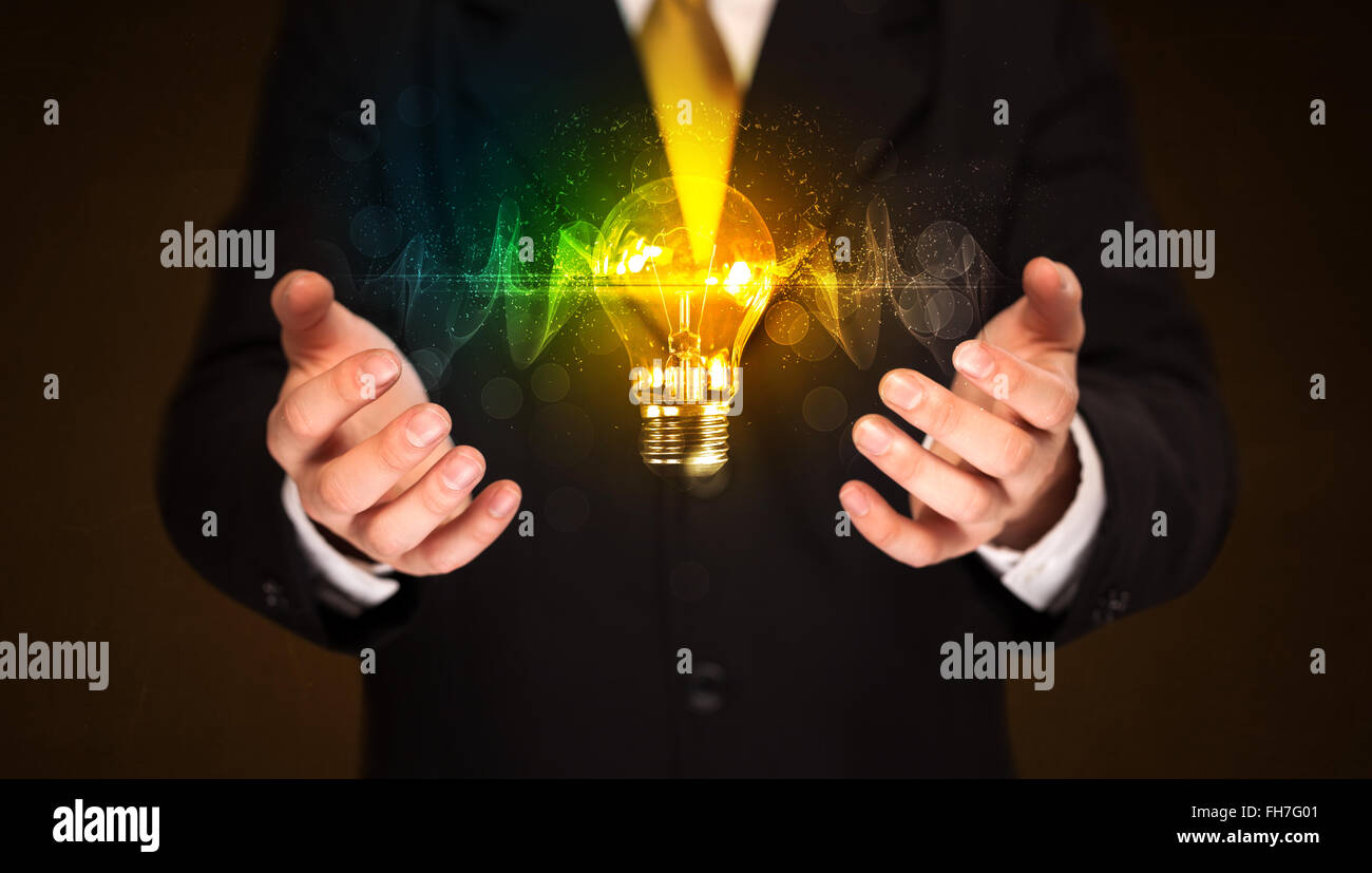 Businessman holding light bulb Stock Photo - Alamy