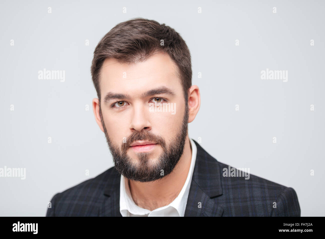 Serious businessman looking at camera isolated on a white background ...