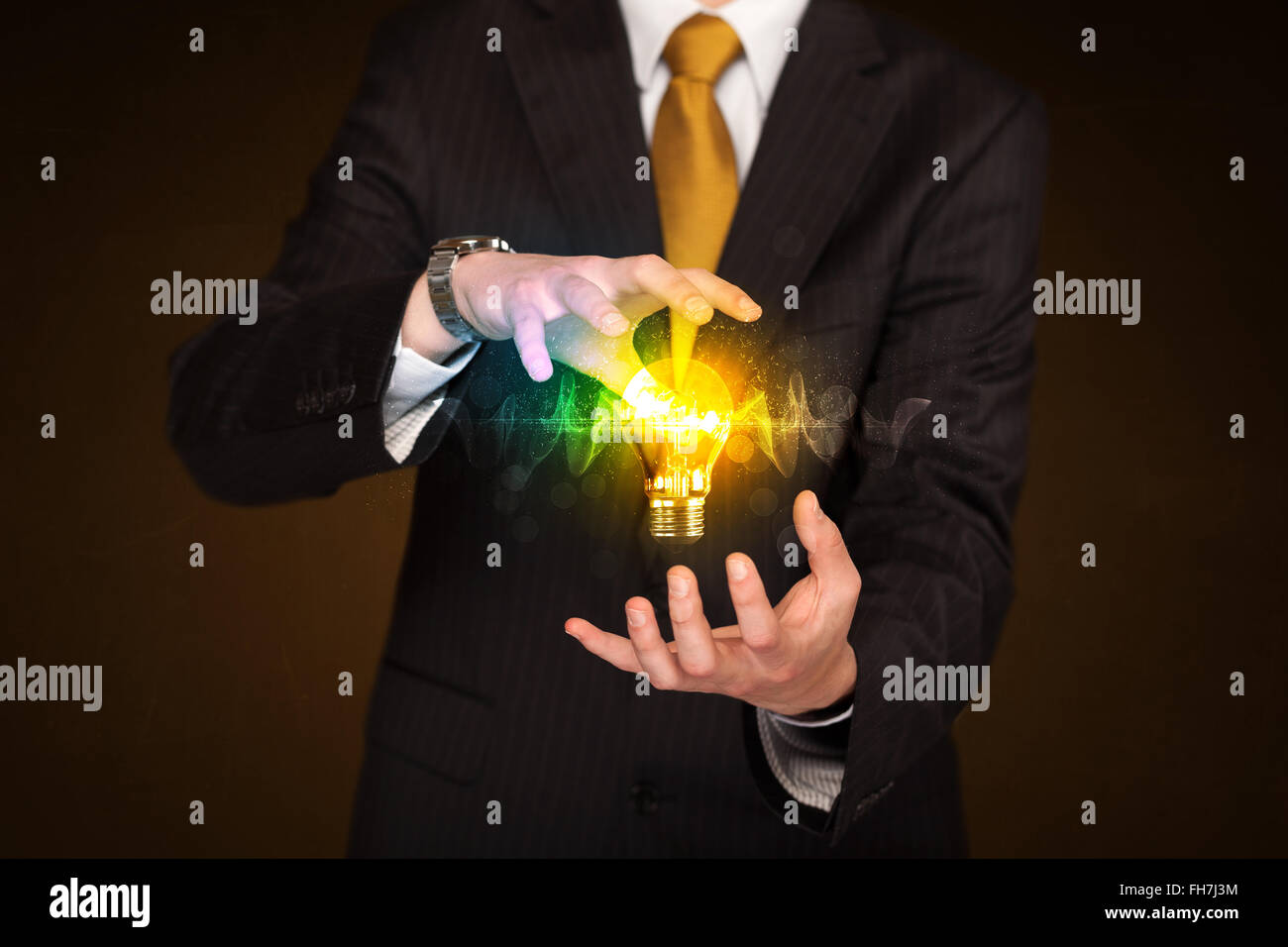 Businessman holding light bulb Stock Photo - Alamy