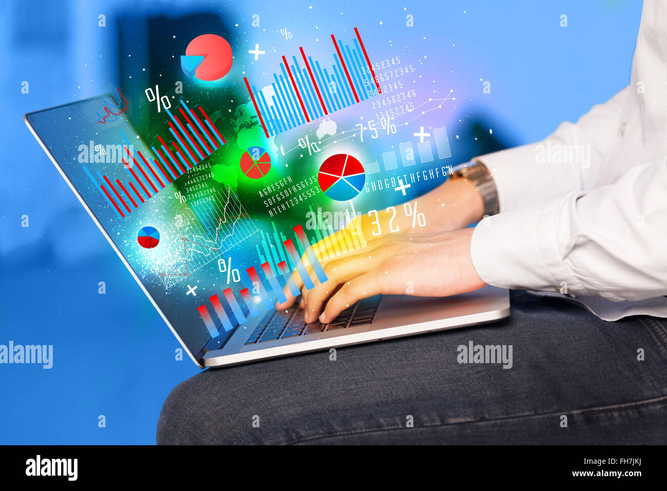 Hand typing on modern laptop notebook computer with graph icons and ...