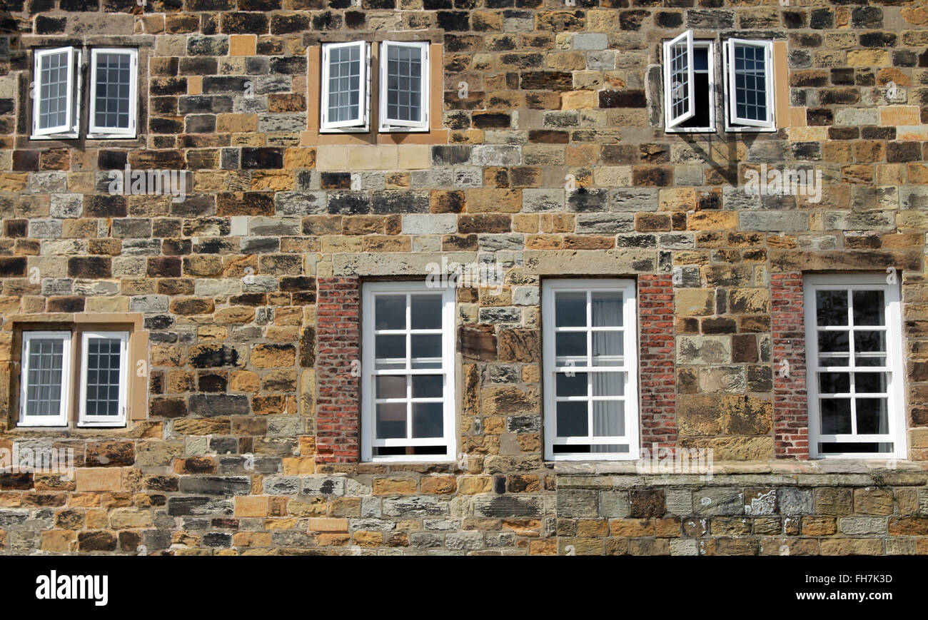 Exterior of a historic stone building with wooden framed windows. Stock Photo