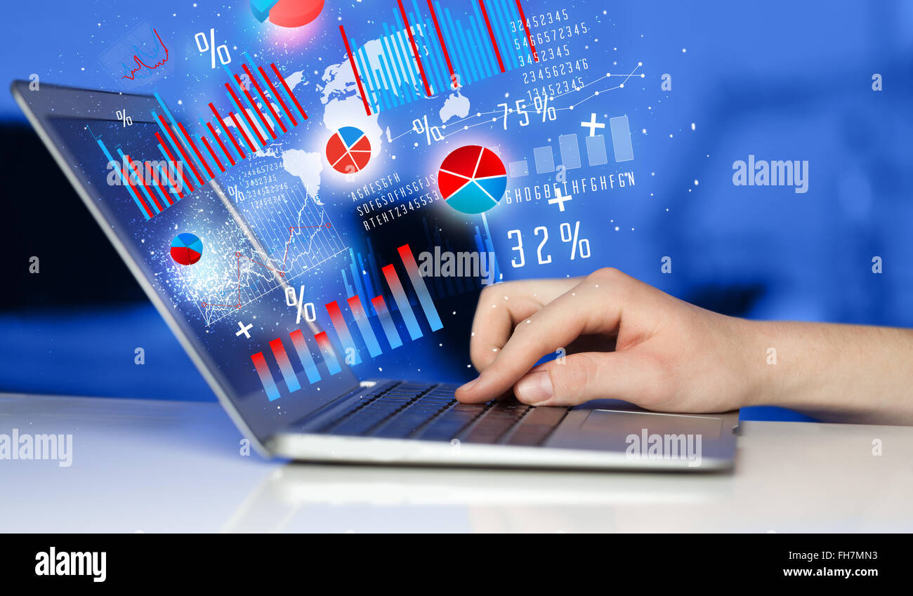 Hand typing on modern laptop notebook computer with graph icons and ...