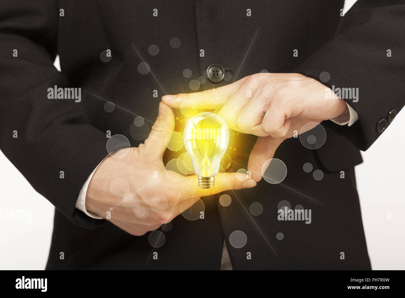Hands creating a form with light bulb Stock Photo - Alamy