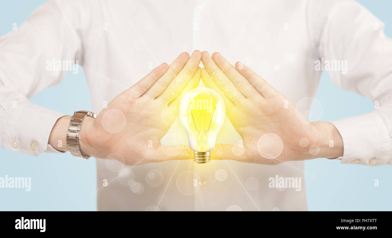 Hands creating a form with light bulb Stock Photo - Alamy