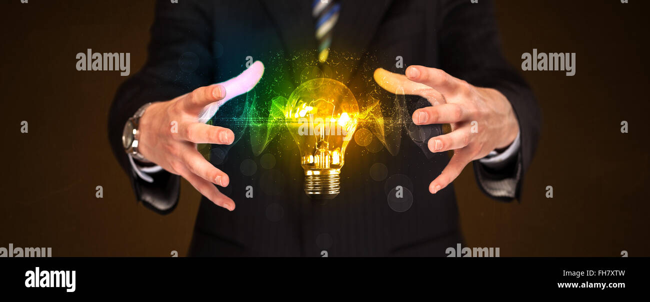Businessman holding light bulb Stock Photo - Alamy