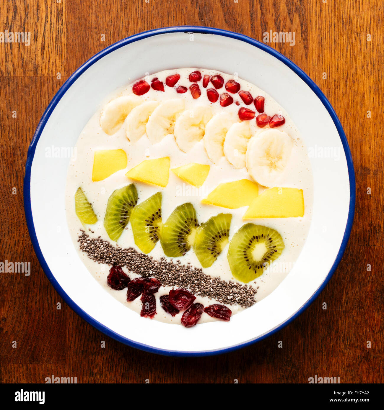 Banana smoothie bowl with kiwi, mango, banana, chia seeds, dried