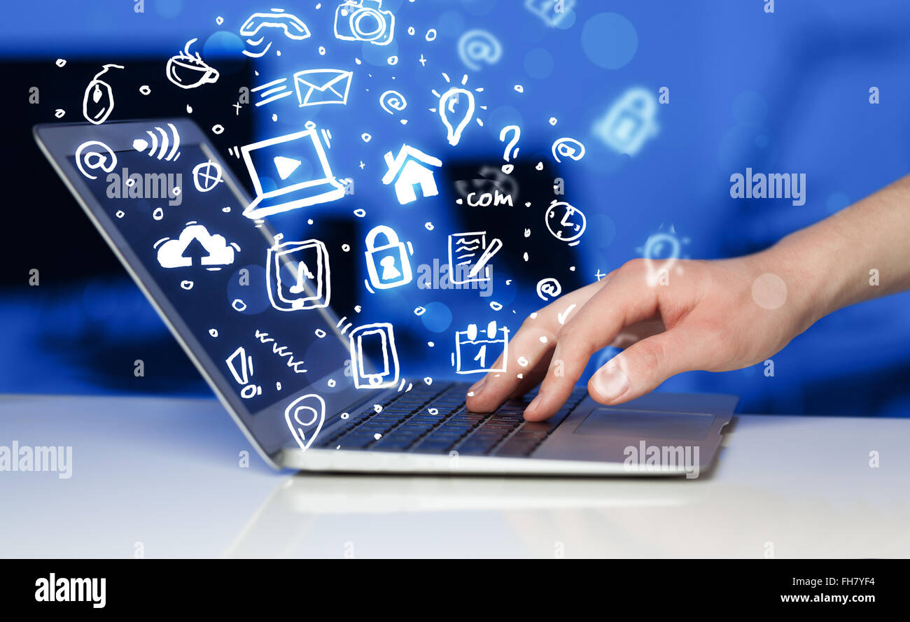 Hand writing on notebook computer with media icons and symbols Stock ...