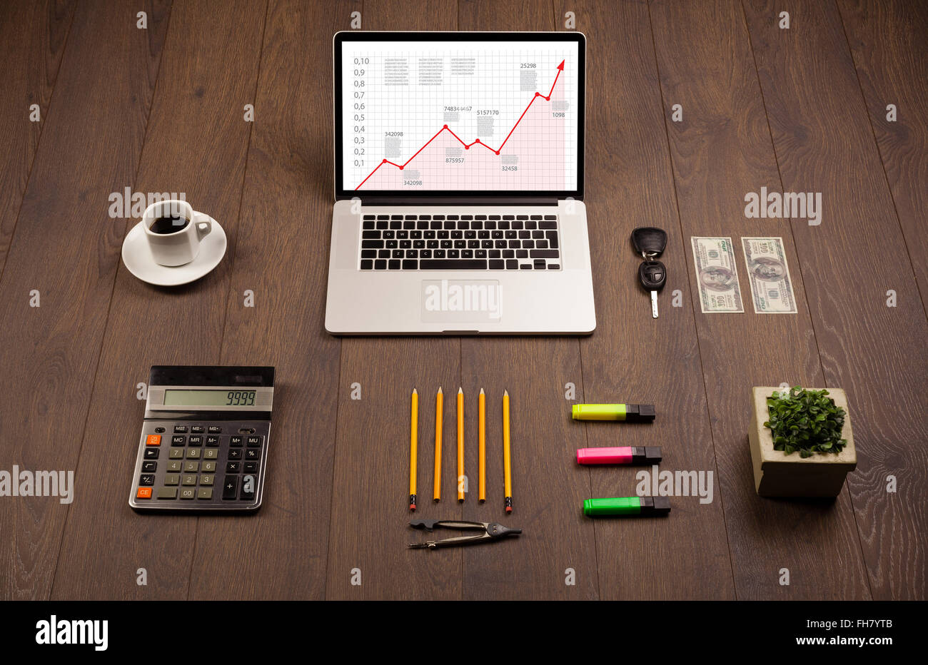 Computer desk with laptop and red arrow chart in screen Stock Photo - Alamy