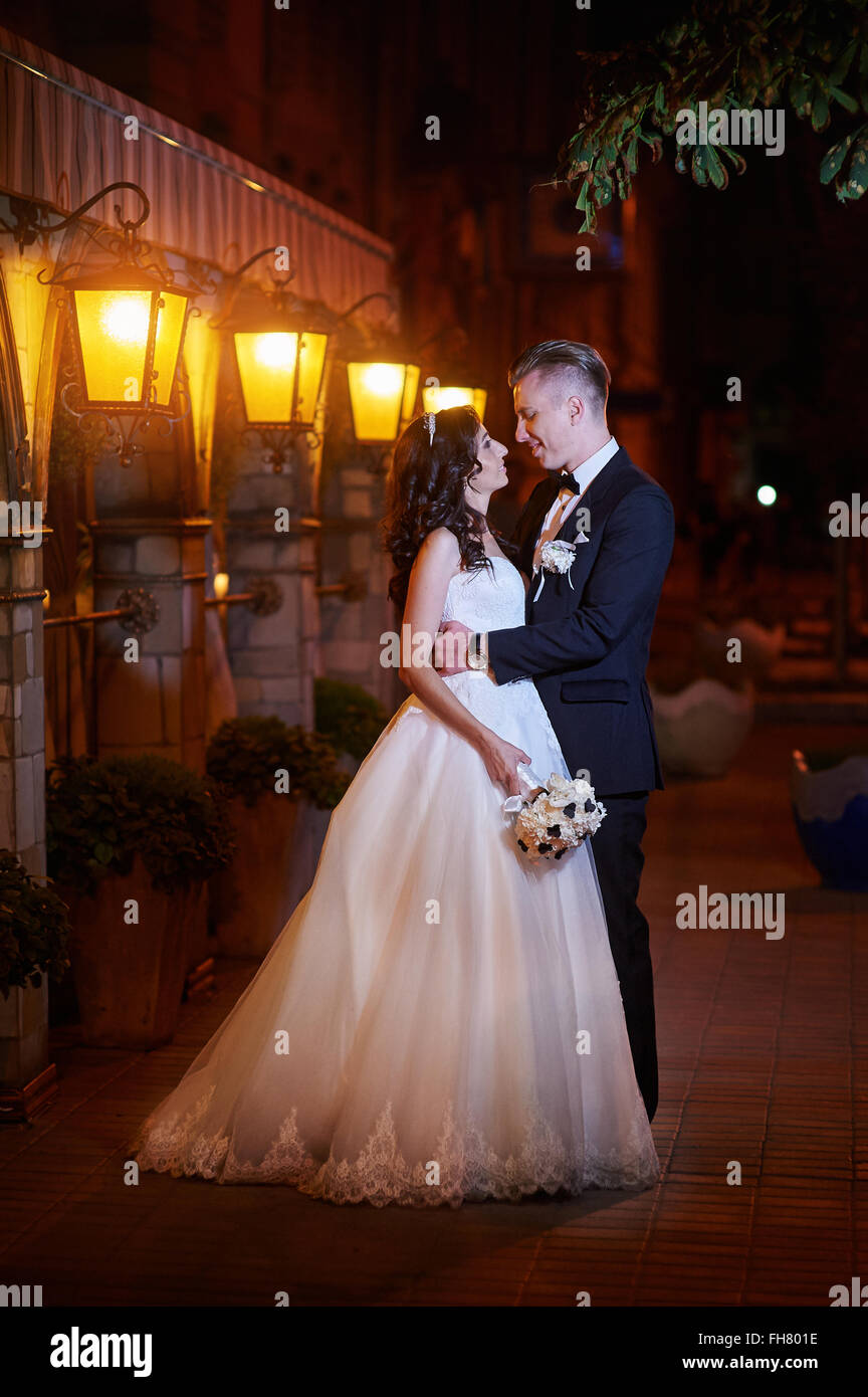 bride and groom walk in city at night Stock Photo