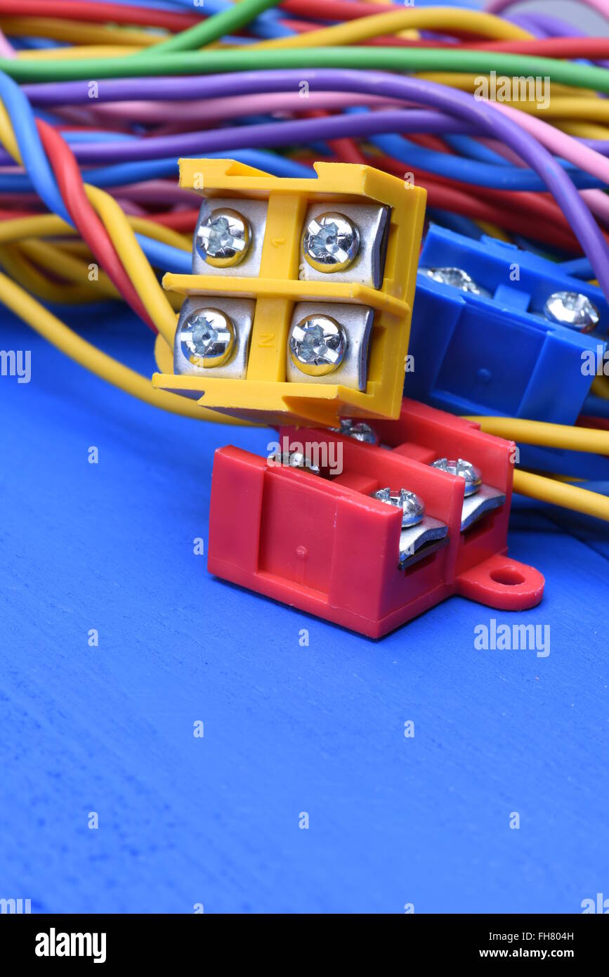 Color electric cables with terminal blocks on blue wooden background Stock Photo